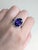 Make an unforgettable impression with this luxurious 8.93 carat oval 13x10mm Tanzanite ring. Nestled in a halo of...