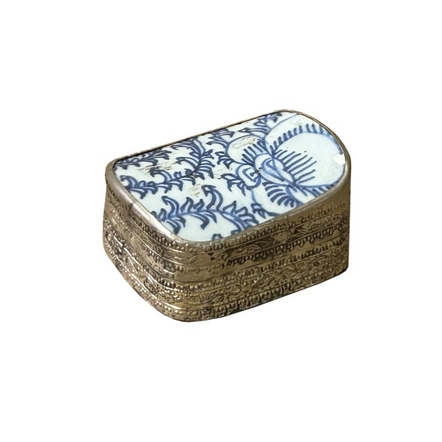 This is a handmade pewter box in an irregular shape with an old white base blue oriental scroll leaf graphic porcelain...