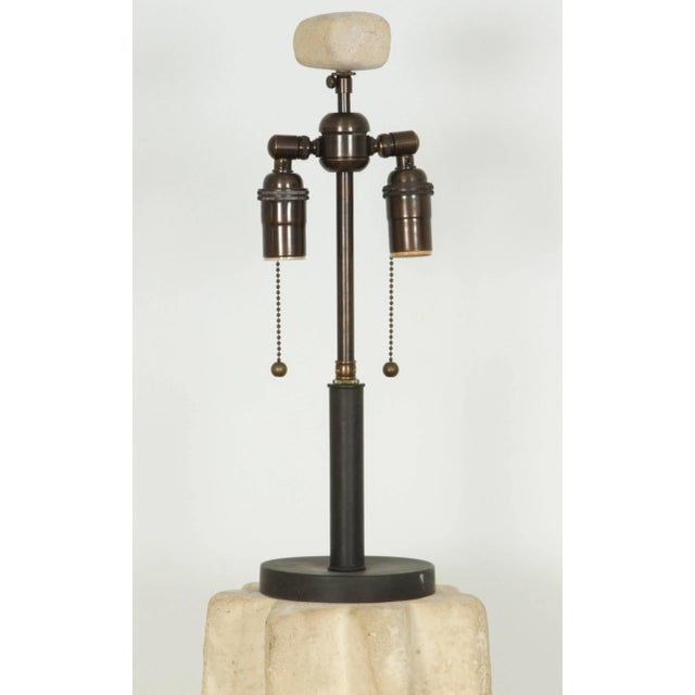 Large fluted table lamp of rough-hewn stone. The lamp has been Newly rewired with an antique Bronze double cluster, and...