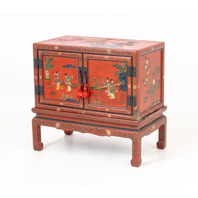 Chinese Red Lacquered Cabinet on Stand, brass hardware, two doors, garden scene to top, figural landscape scene to sides,...