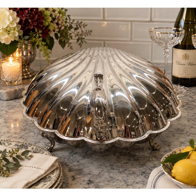 An impressive vintage silverplate buffet server rendered as an oversized scallop shell. The sculptural hinged form opens...