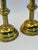 Elegant pair of vintage brass-plated metal candlesticks featuring finely etched column details and warm aged brass tones....