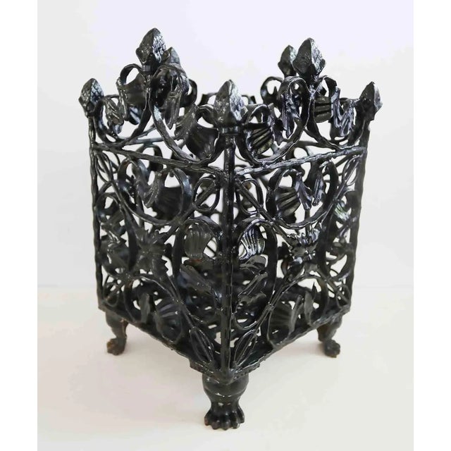 Early 20th century wrought iron basket/planter with lion claw feet. Ornate foliate and acorn design.