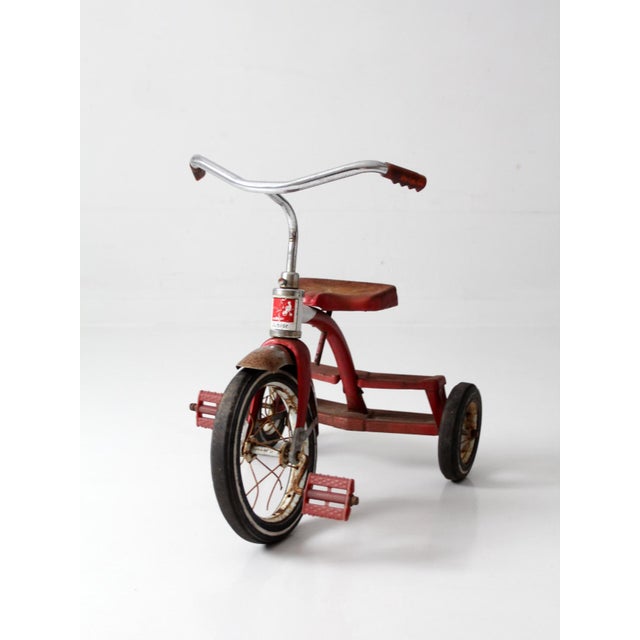 A vintage American Machine and Foundry “Junior” tricycle in its original red finish, dating to the late 1950s–early 1960s....