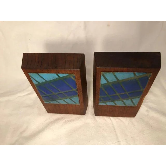 Pair of Mid-Century Modern walnut and enamel bookends. Signed by Ernest John. The perfect accessory to a midcentury...