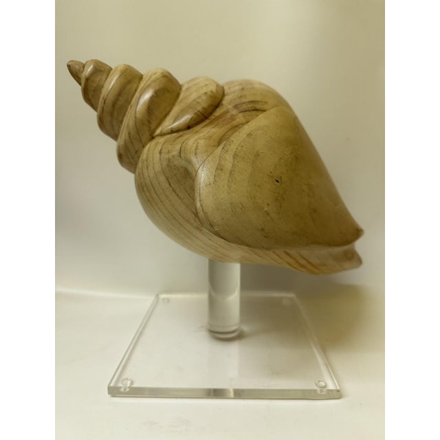 Infuse your space with organic coastal elegance through this stunning vintage hand-carved wooden conch shell sculpture....