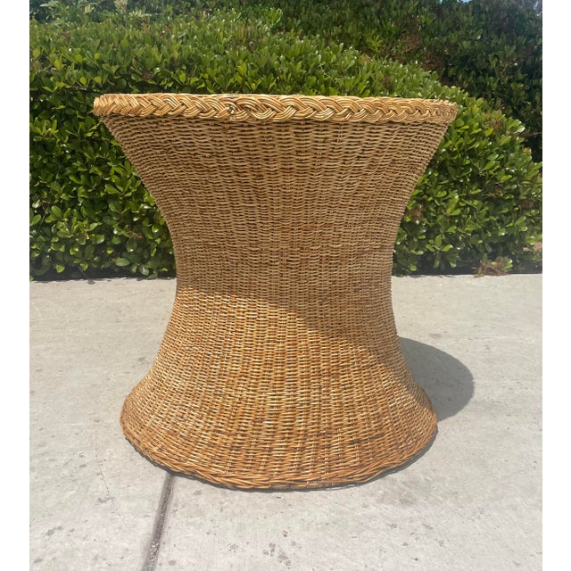 Vintage wicker dining table, featuring a sculptural pedestal silhouette and tightly handwoven rattan construction. The...