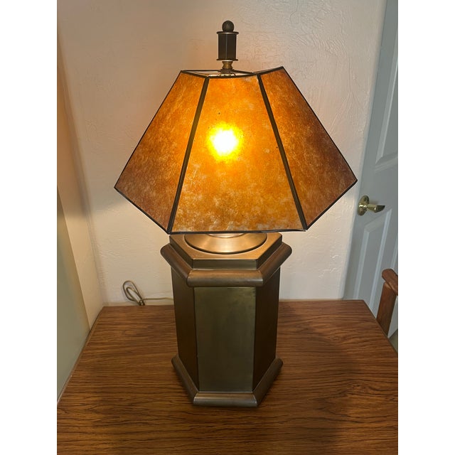 This vintage Arts and Crafts style table lamp, distinguished by its prominent amber mica paneled shade and an octagonal or...