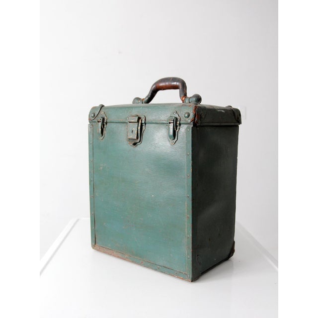 This early 20th-century industrial utility tool box features a green painted exterior, riveted steel corner guards, aged...