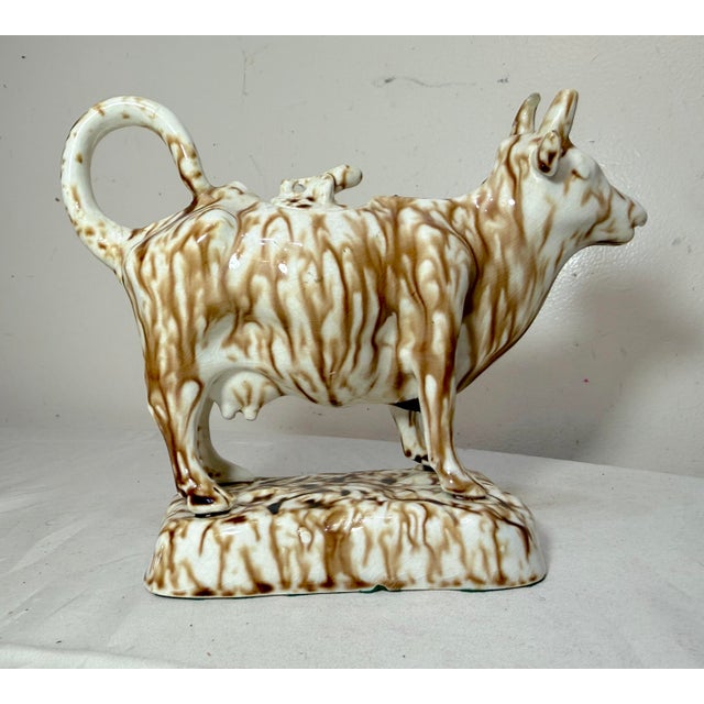 This early antique drip brown glaze Staffordshire pottery cow creamer sculpture is a unique and exceedingly rare piece...
