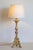 This early 20th-century tripod candlestick, crafted from gilded wood, has been elegantly converted into a lamp while...