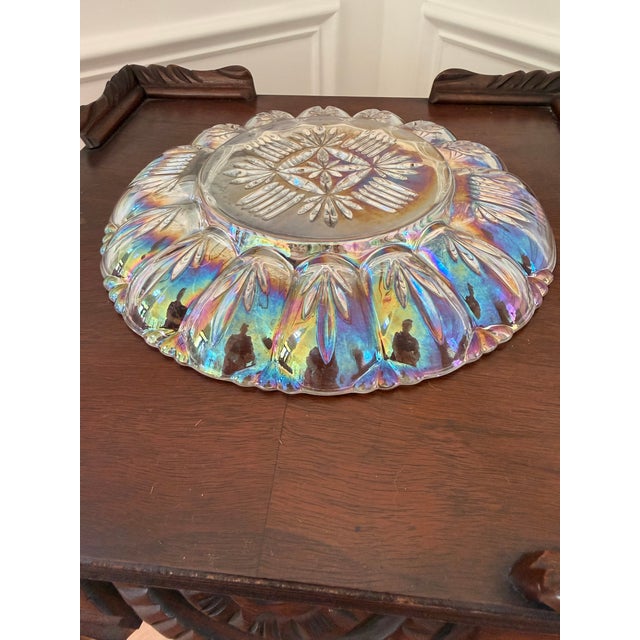 Striking vintage carnival glass serving bowl featuring brilliant rainbow iridescence and an elaborate pressed-glass...