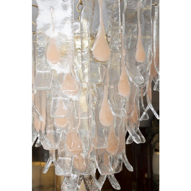 This is a striking Italian Murano glass chandelier featuring cascading hand-blown tronchi-style glass elements suspended...