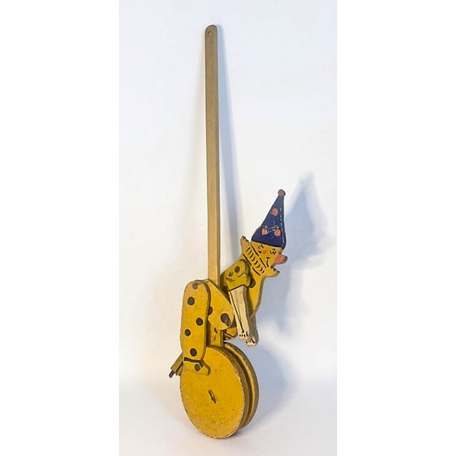 This is a vintage folk art wooden push toy from the early-to-mid 20th century. It is a handcrafted articulated pull toy...