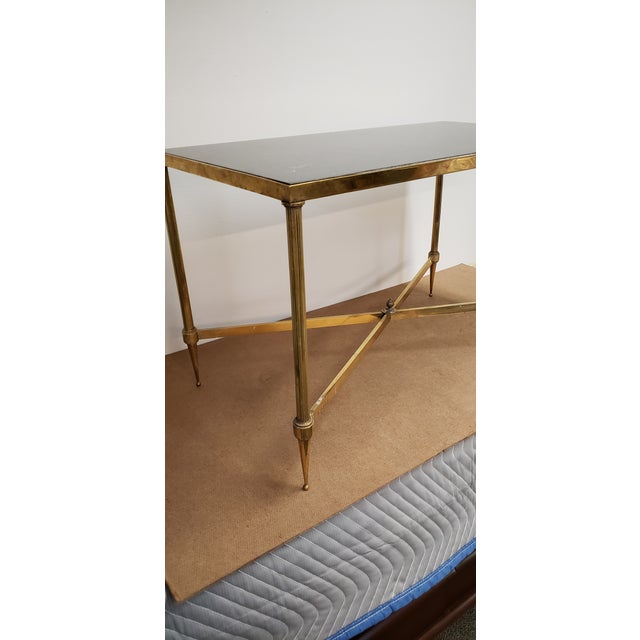 Maison Bagues brass coffee table. French circa 1950 with black high honed polished stone top. 15.75" wide x 29.5" long x...