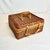 This is a lovely darker stained wicker suitcase style basket. It has a two-rattan clasp closure and rattan wrapped handles...