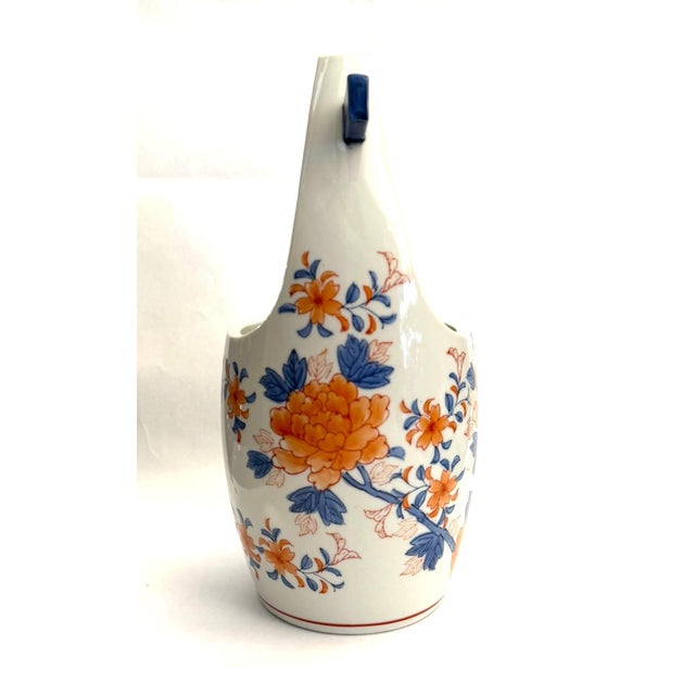 The clean white porcelain basket form vase represents the Imari decorative tradition that originated in 17th century...