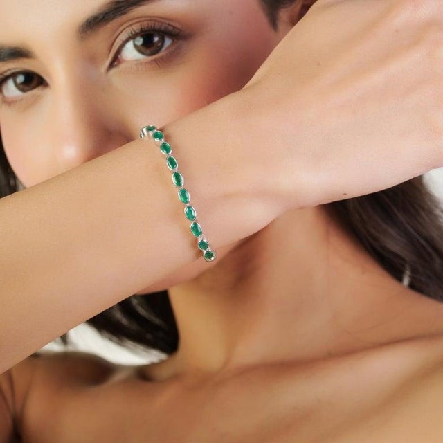 This elegant tennis bracelet is crafted in 925 sterling silver and beautifully set with 29 natural oval-shaped green onyx...