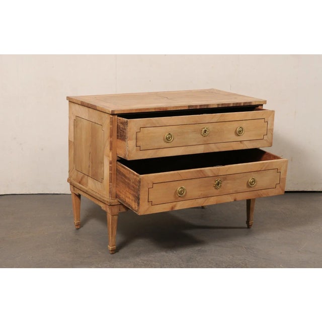 A French bleached-wood raised commode with two drawers, from the turn of the 18th and 19th century. This antique chest...