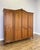 An elegant Vintage French Louis wardrobe in oak, featuring four beautifully panelled doors, a sweeping shaped top with...