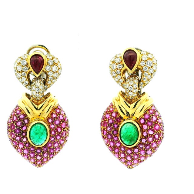 Luxurious vintage circa 1980 drop earrings crafted in 18K yellow gold, featuring a rich combination of rubies, emeralds...