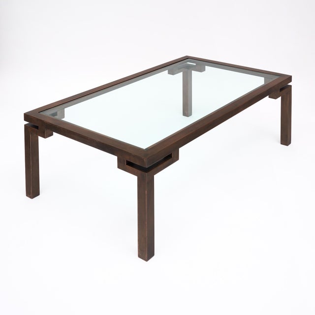 Coffee table from France with a chinoiserie style copper structure. The structure supports a clear glass top. This piece...