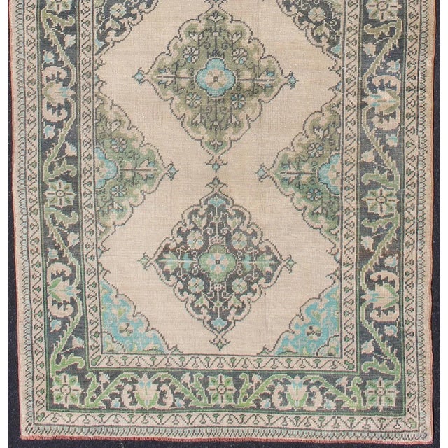 Turkish Oushak runner with Medallion design in dark blue, blush, aqua and green. Floral Medallion design Oushak runner...