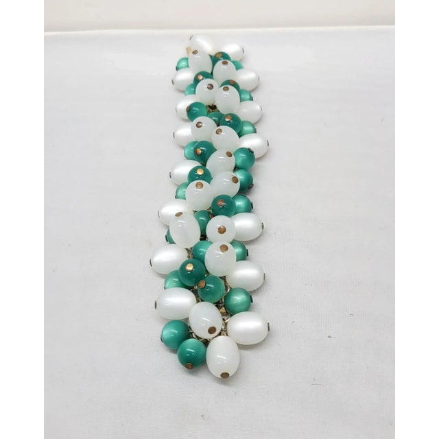 This is part of Chairish’s Costume Jewelry assortment. 1950s or early 1960s goldtone ovoid white and green "moonglow"...