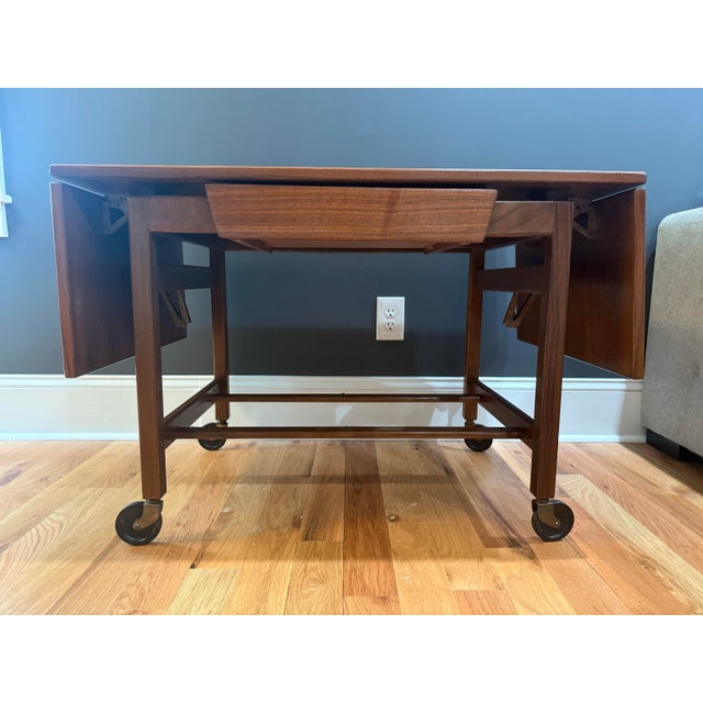 Elegant and versatile mid-century modern teak drop-leaf tea or serving cart, circa 1960s, in the style of Jens Risom....