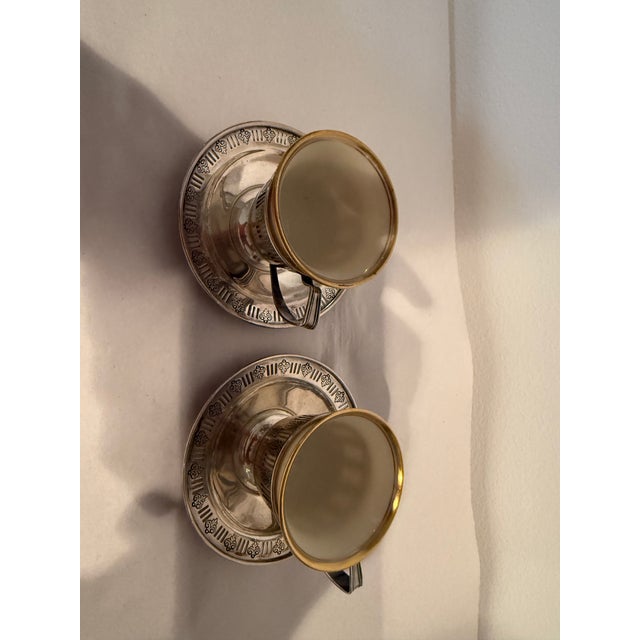 Sterling holders for a pair of Lenox demitasse cups and saucers and a pair of salt cellar lattice holders for a formal...