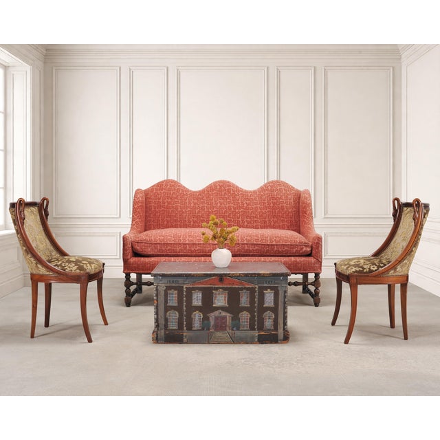 An elegant country English camel or hump back sofa settee crafted in the William and Mary Baroque taste. The distinctive...