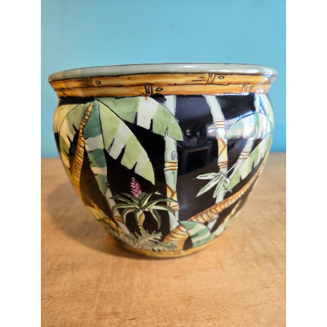 This is a vintage Andrea by Sadek “Tropical Jungle” ceramic planter featuring hand-painted palm and bamboo designs by...