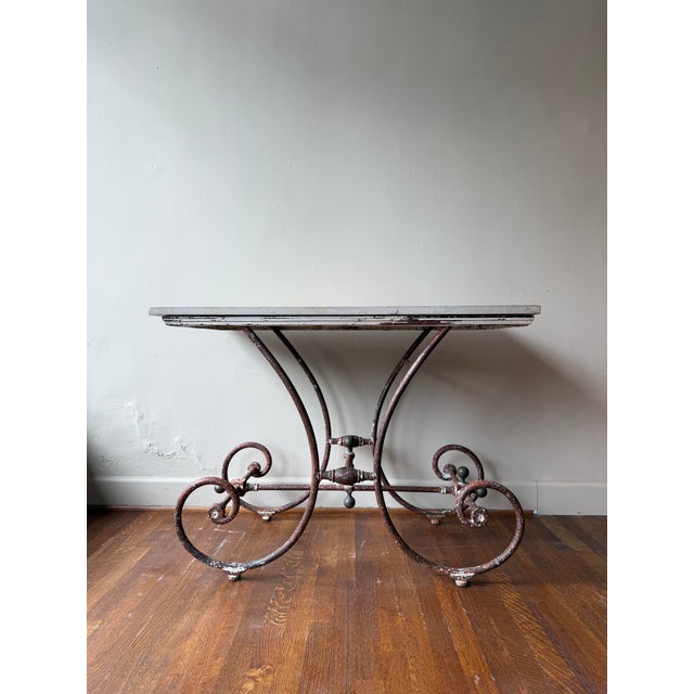 This 1880 French Butcher Table combines a sturdy stone top with aged iron legs, reflecting authentic and industrial charm....