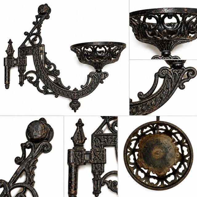 BRADLEY & HUBBARD Ornate black cast iron wall mount candle sconce with openwork basket and swing arm, shown with a...