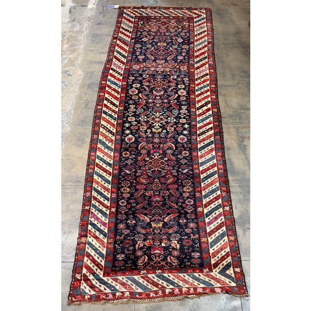 Dating to approximately 1900, this antique Caucasian runner is a handwoven wool rug representing the richly patterned...