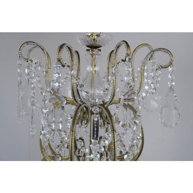 Monumental Italian 24 light crystal beaded arm chandelier adorned with garlands of crystal swags, crystal spheres, and...