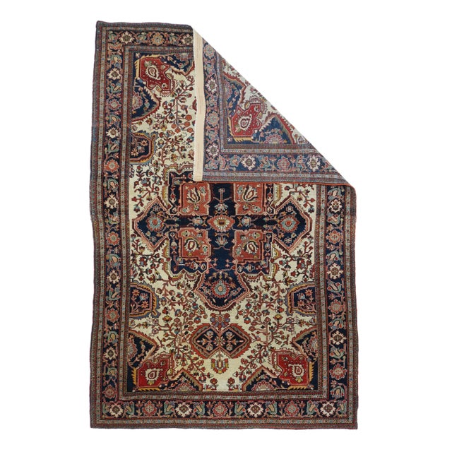 Antique Persian Farahan Sarouk Rug 4'6" x 6'9". A mushroom-lobed navy equal arm cross is set on a red square in the centre...