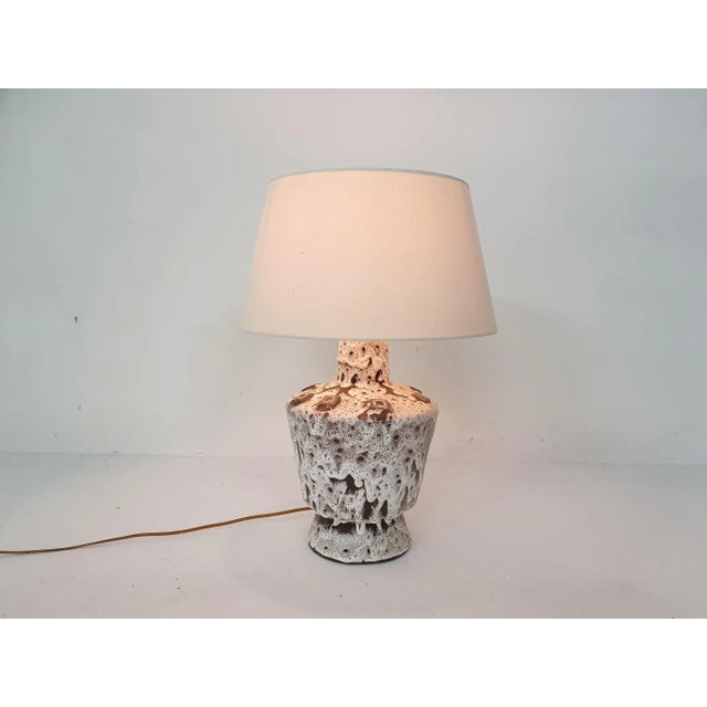 White and brown ceramic table light with white lamp shade. It has the original wiring. This piece is attributed to the...