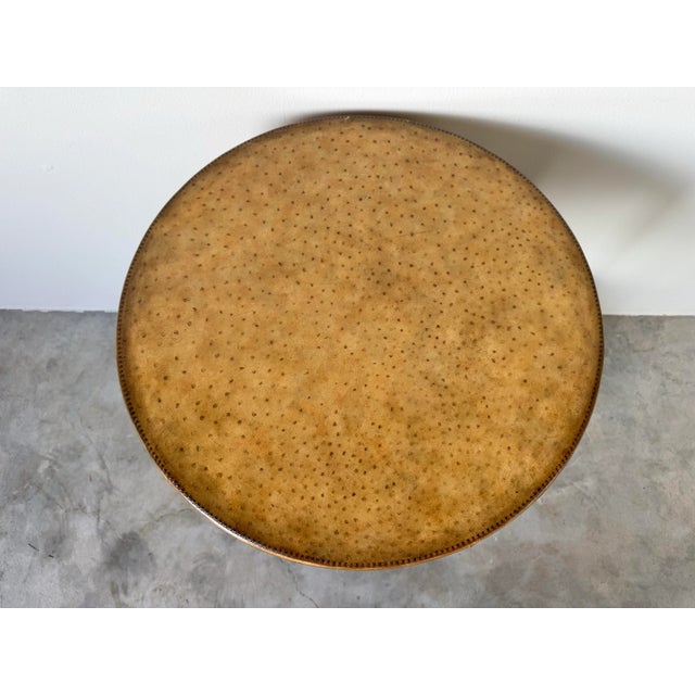 A distinctive vintage two-tier round end table by Maitland-Smith, wrapped in luxurious faux ostrich leather. This...