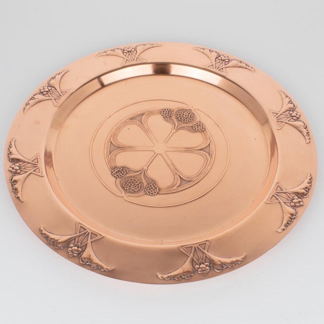 This stunning, large platter, serving tray, or centerpiece in polished copper was designed and crafted circa 1910. The...