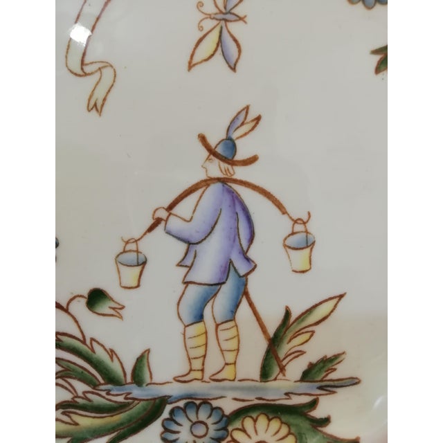 Decorative plate by Gio Ponti for Richard Ginori from the I Mestieri series. This plate features a water carrier. The...