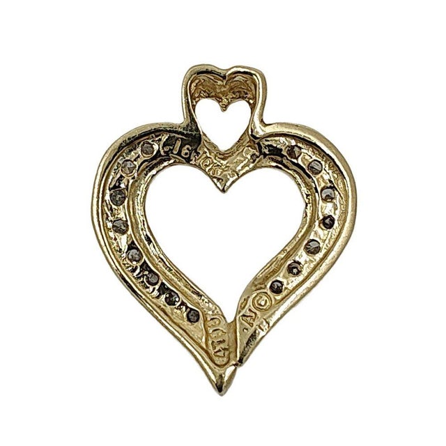 Estate 10K diamond heart pendant. This estate heart pendant is crafted in 10 karat yellow gold featuring .12 carat total...