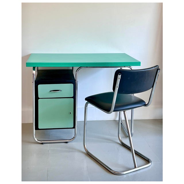 Colourful Modernist desk with chrome tubular structure, black metal case with coloured drawer, green wooden desk top. The...