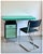 Colourful Modernist desk with chrome tubular structure, black metal case with coloured drawer, green wooden desk top. The...