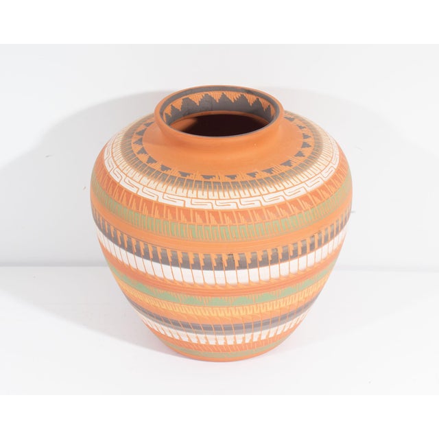 A Native American vessel by Navajo artist Laura Bahe. This vessel sports a pattern which wraps around its surface in...