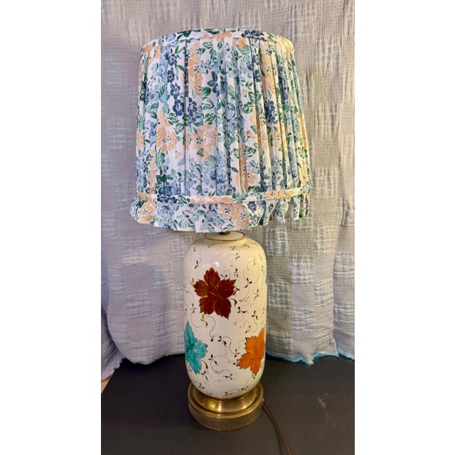 A charming 1950s table lamp with a cream-glazed ceramic body. It is hand-painted with large grape leaves in turquoise,...