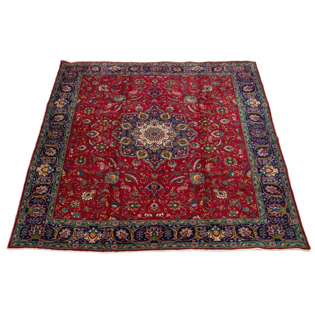 Explore the charm of this handmade vintage Tabriz rug, crafted from rich red wool. Adorned with an intricate rosette...