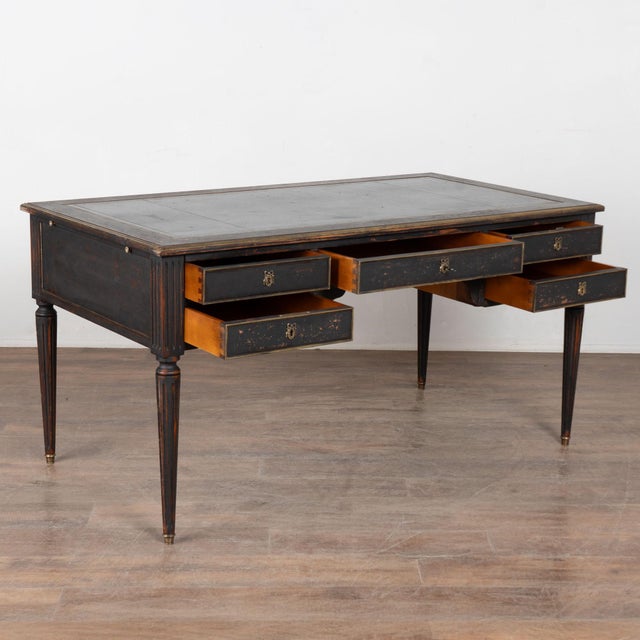 Early 20th century Swedish desk fitted with five drawers. The desk stands on turned, fluted legs with brass-capped feet...