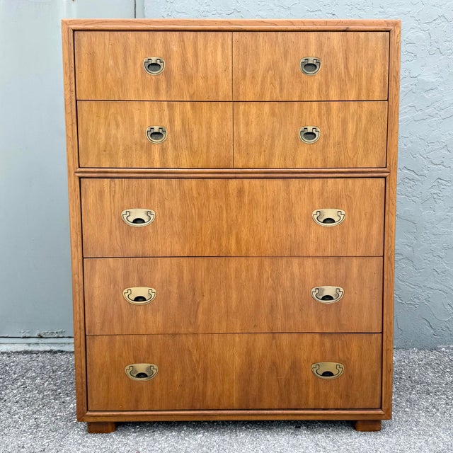 A handsome vintage highboy dresser from Drexel’s Passages collection, featuring a warm walnut finish and Campaign-inspired...