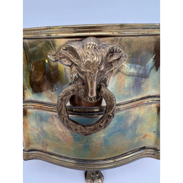 Stunning Mottahedeh solid brass jardiniere. This lovely planter is adorned with two rams head handles along with four lion...